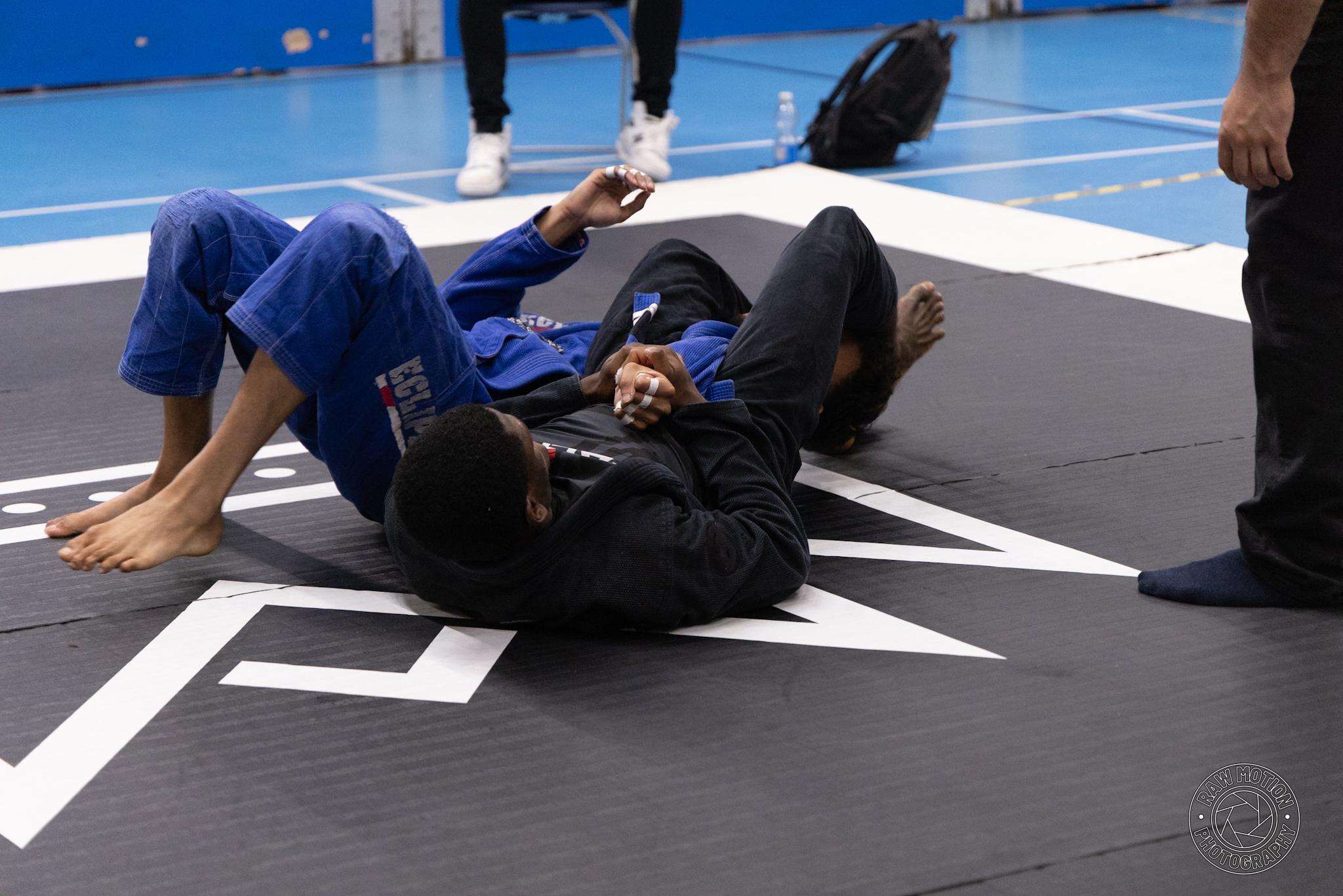Applying an armbar during a BJJ competition